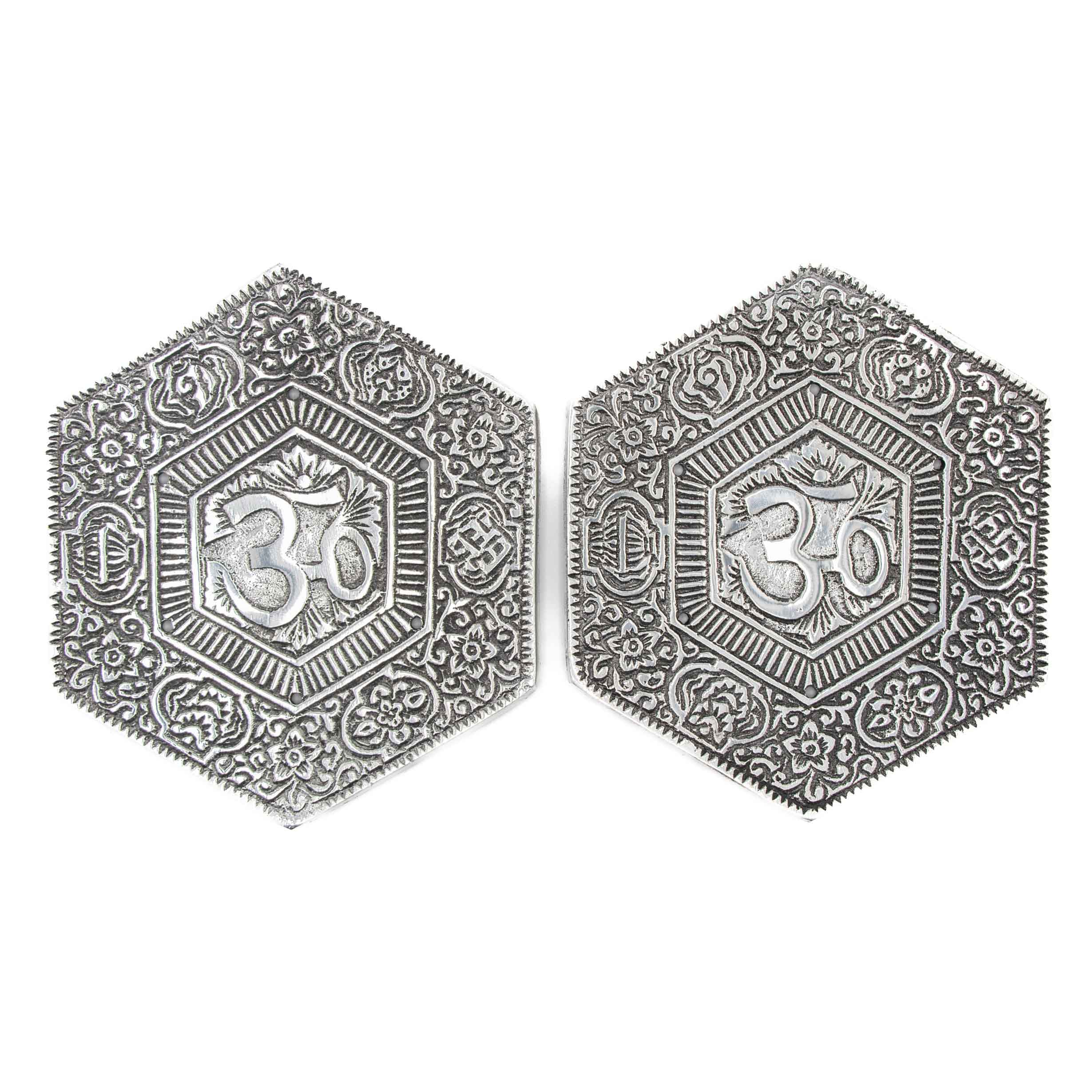 Two hexagonal silver-toned aluminum incense burners featuring an embossed Om symbol in the center surrounded by intricate floral and geometric patterns.