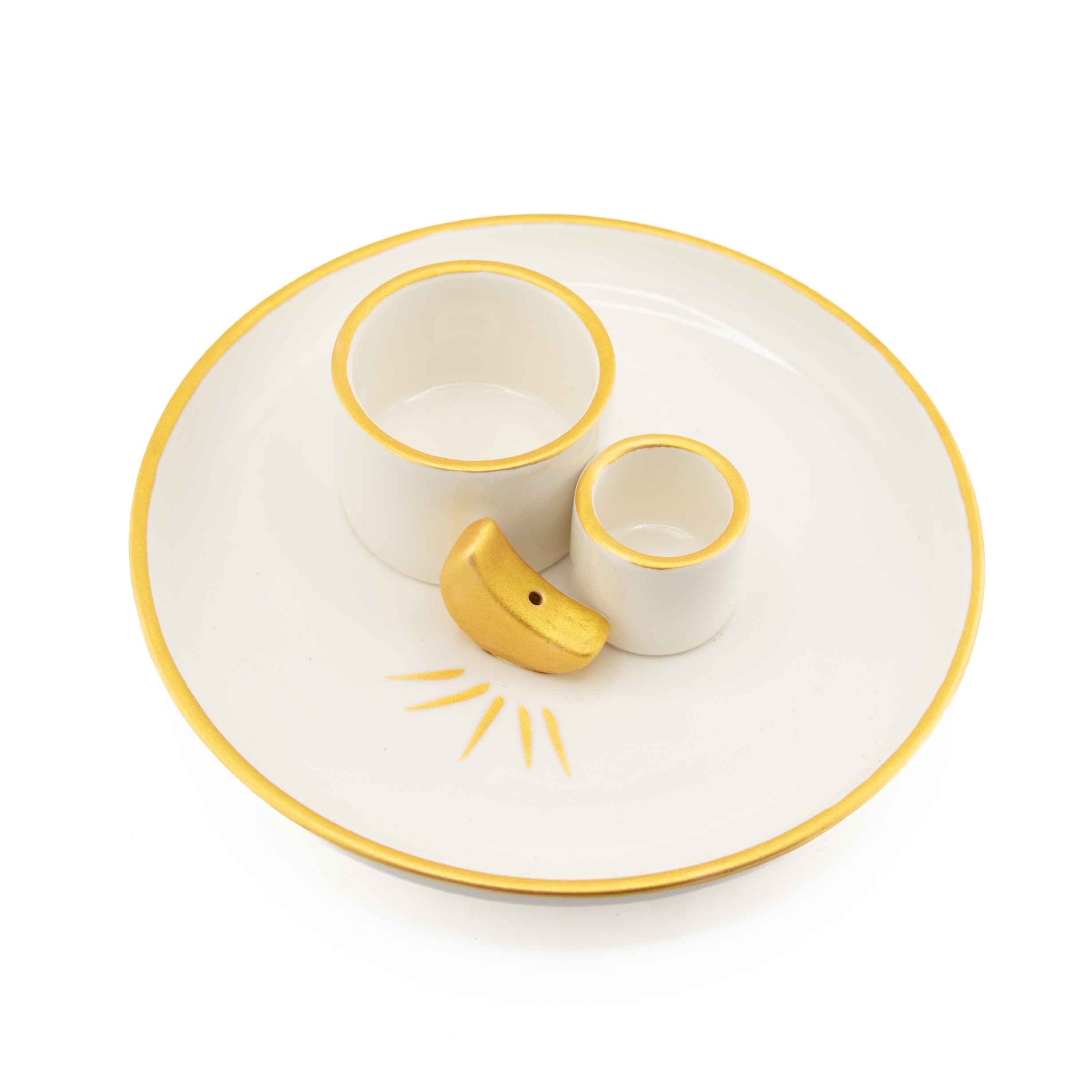 A white ceramic ritual plate with gold trim featuring two integrated holders and a small gold crescent moon incense burner in the center.